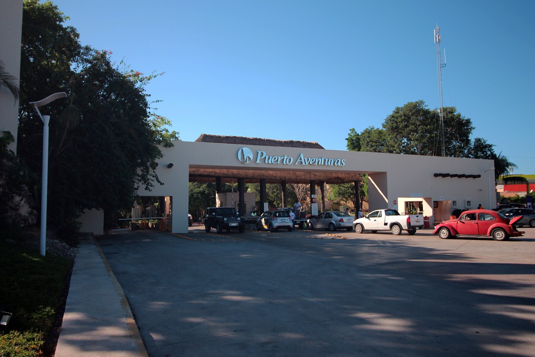 Entrance gate of the Puerto Aventuras resort community in Quintana Roo with the Puerto Aventuras sign above the access road