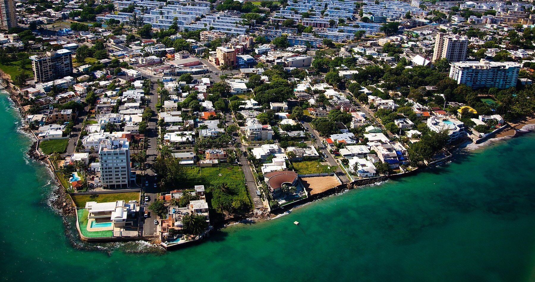 Aerial view of the Santurce district of San Juan, Puerto Rico, with apartment blocks, houses, a lagoon and the Atlantic coast