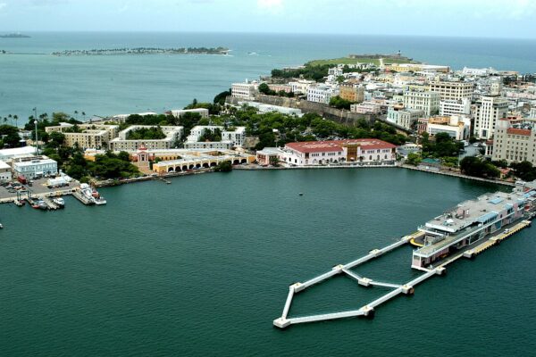 Aerial view of the Old San Juan waterfront, with the city's old stone fortifications and a cruise pier on San Juan Bay.