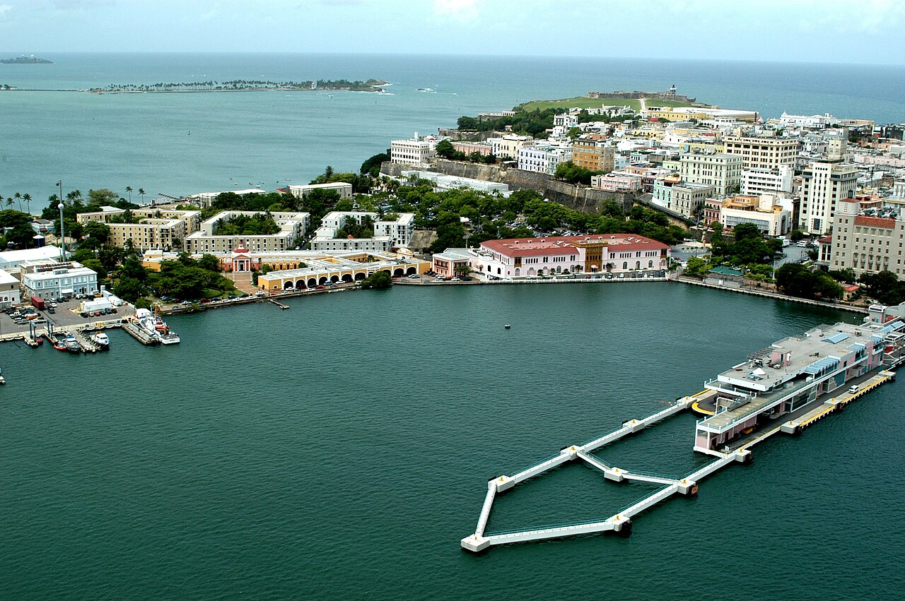 Aerial view of the Old San Juan waterfront, with the city's old stone fortifications and a cruise pier on San Juan Bay.