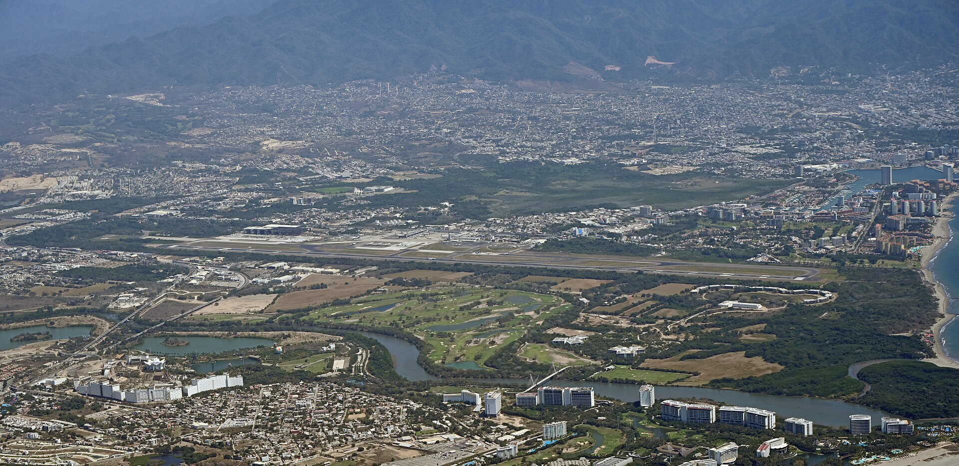 Puerto Vallarta travel guide: aerial view of Licenciado Gustavo D&iacute;az Ordaz International Airport, Marina Vallarta and the city spreading to the mountains