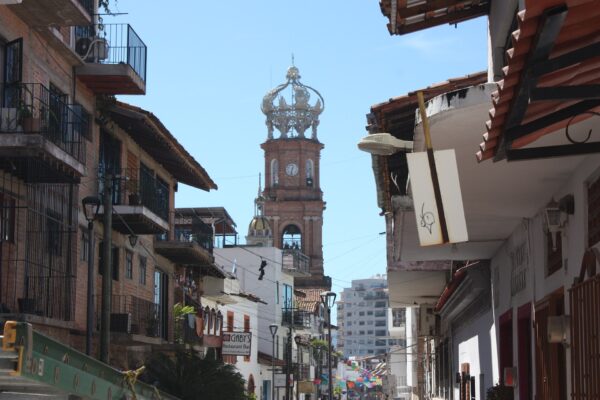 Puerto Vallarta travel guide: the crowned bell tower of Our Lady of Guadalupe church above a street of balconied buildings in downtown Puerto Vallarta