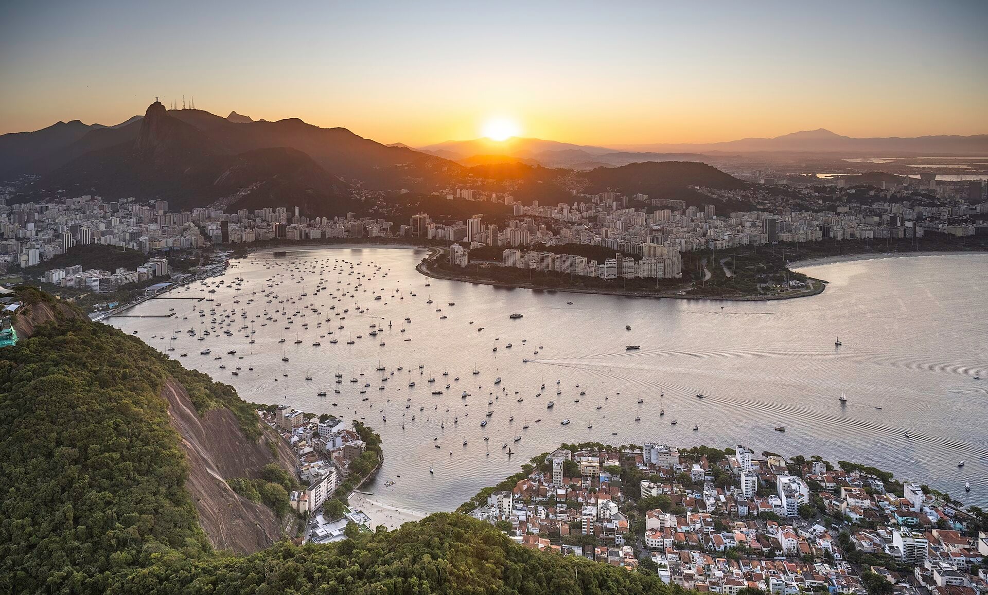 Botafogo Bay full of moored boats at sunset, with the city of Rio de Janeiro and the Corcovado mountain with Christ the Redeemer behind