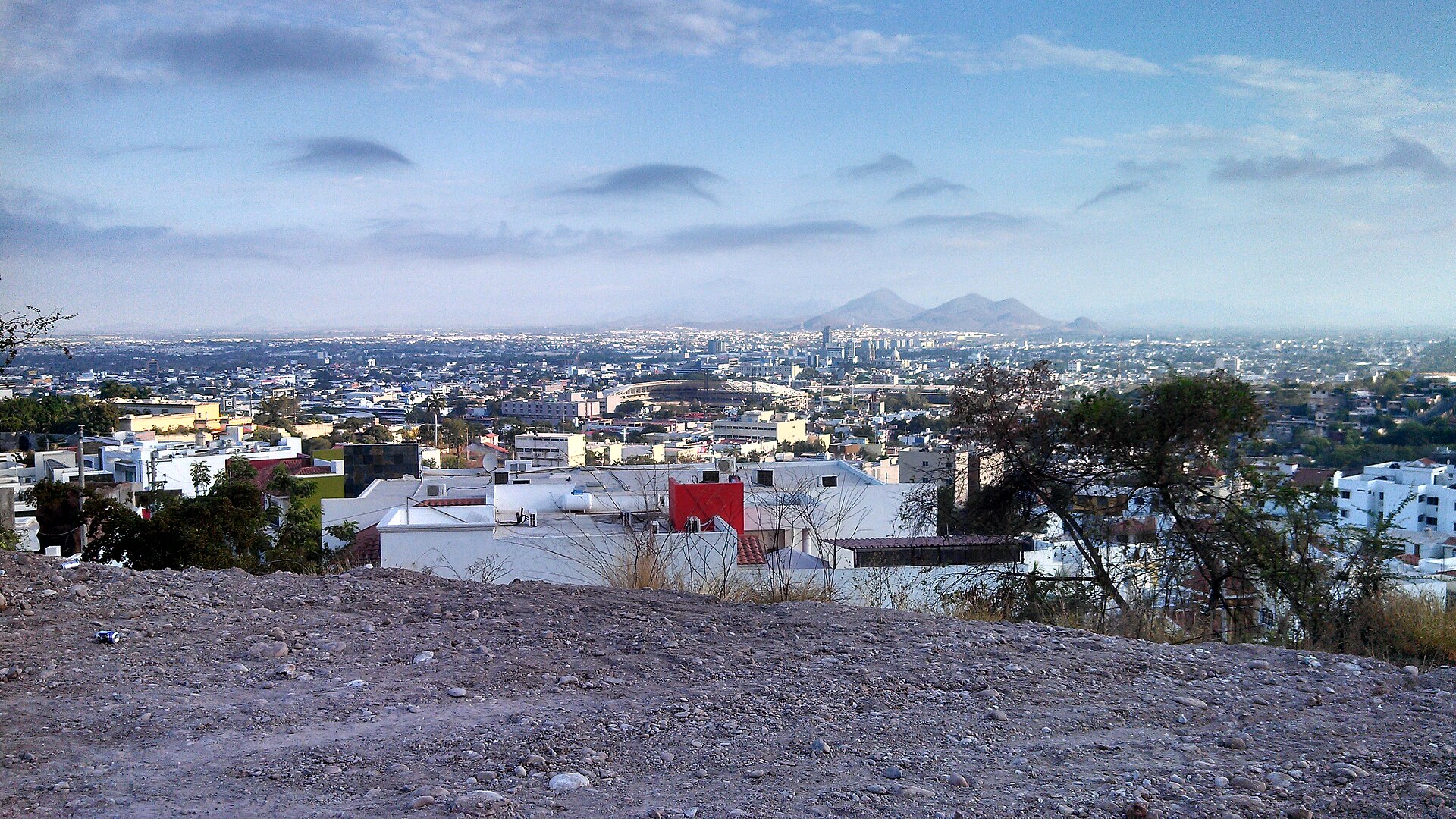 Panoramic view over the rooftops of Culiacán with the Tomateros baseball stadium and hills on the horizon