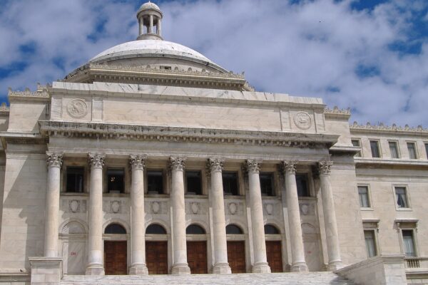 White marble Capitol of Puerto Rico in San Juan with its dome, columns and entrance steps under a cloudy blue sky