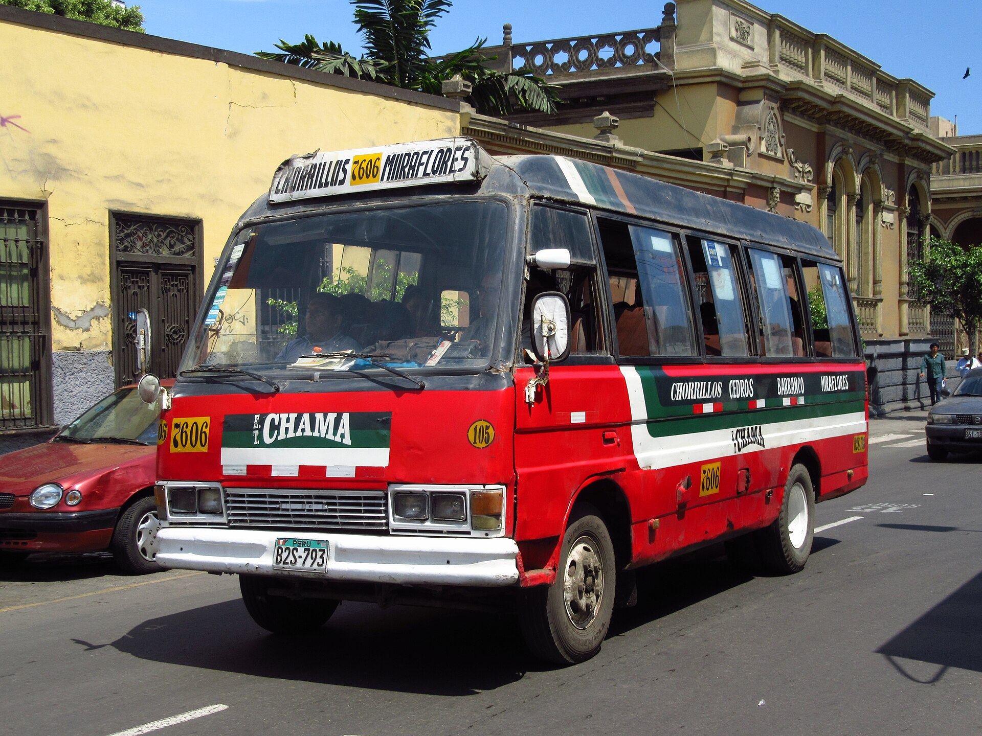 A red and white minibus marked Chorrillos and Miraflores drives along a Lima street past old buildings