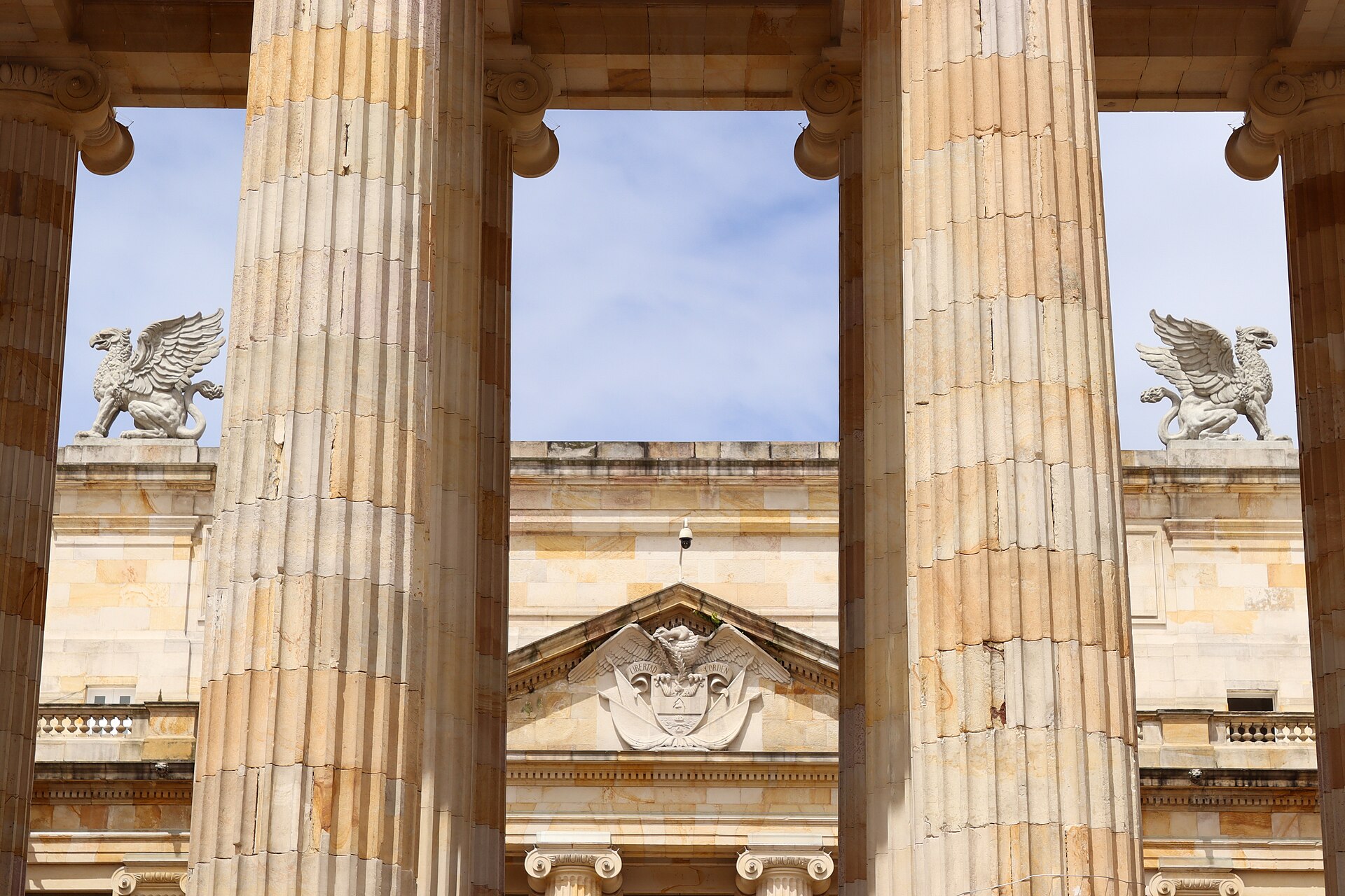 Stone columns and a sculpted pediment with the national coat of arms at the Capitolio Nacional in Bogotá