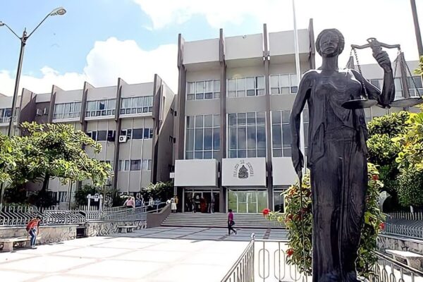 The Supreme Court of Justice building in Tegucigalpa with a statue of Lady Justice holding scales in the foreground