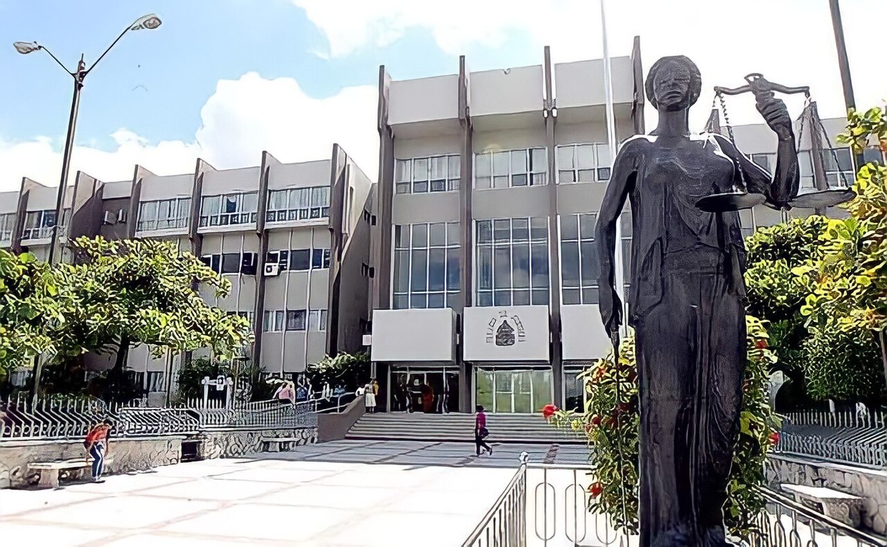 The Supreme Court of Justice building in Tegucigalpa with a statue of Lady Justice holding scales in the foreground