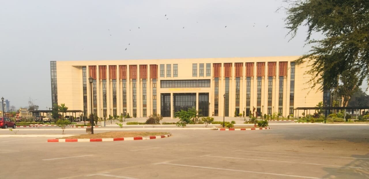 National Assembly building in Brazzaville, a wide cream-coloured government building with red panels and a car park in front