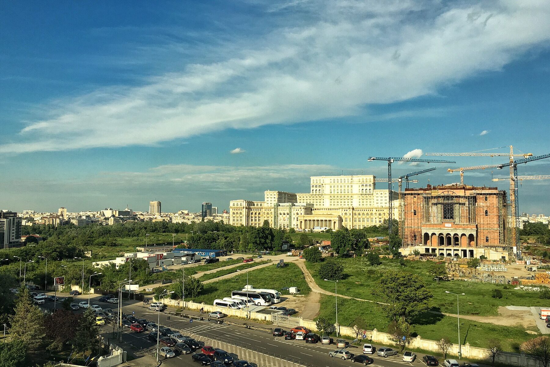 The Palace of the Parliament in Bucharest seen across the city under a blue sky