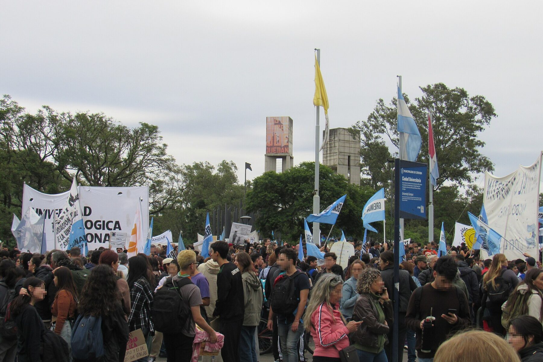 A crowd of students and staff with Argentine flags and university banners gathered at Ciudad Universitaria in Córdoba