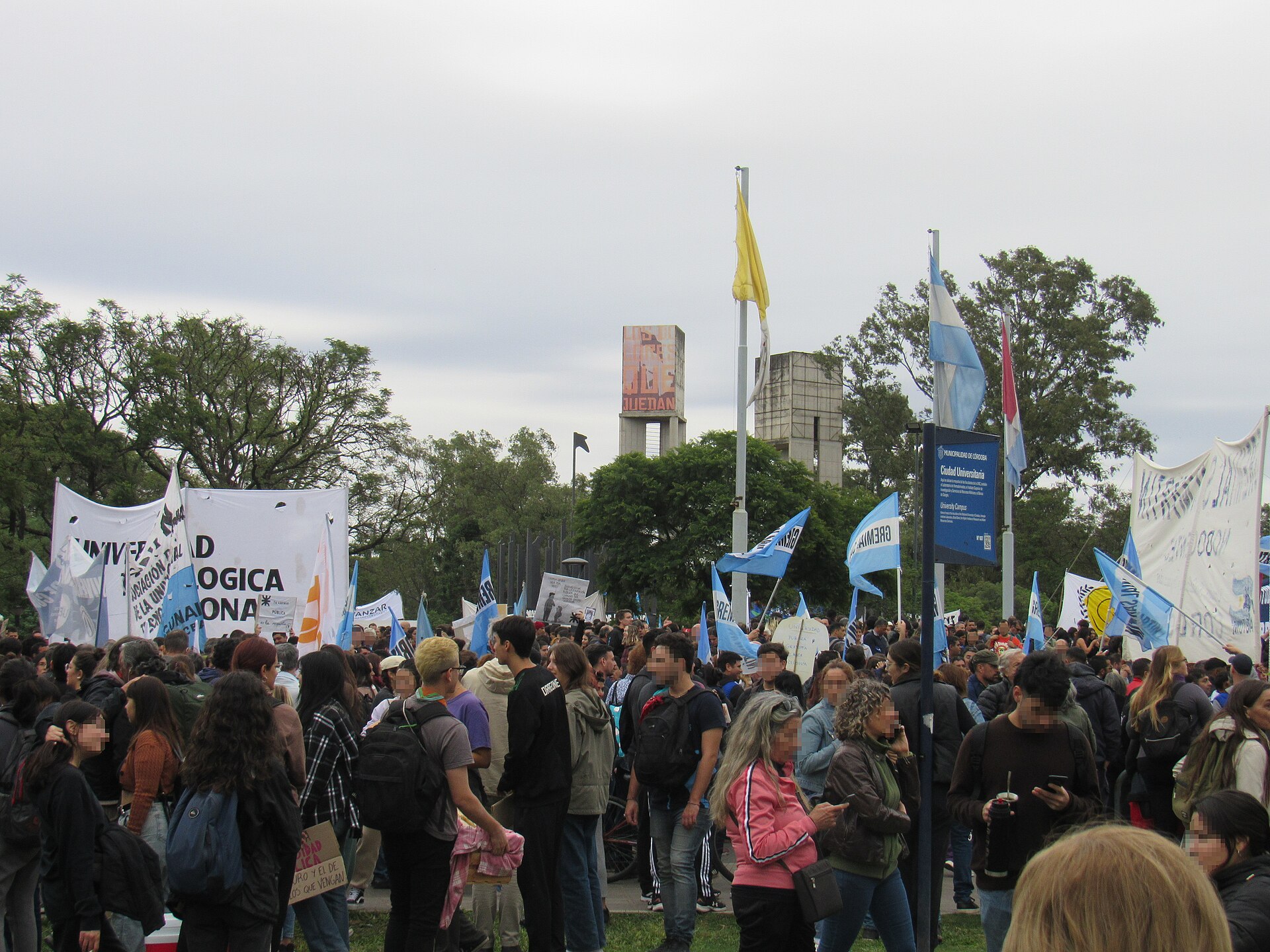 A crowd of students and staff with Argentine flags and university banners gathered at Ciudad Universitaria in Córdoba