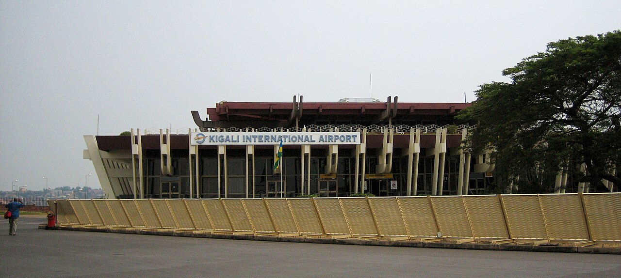 Kigali International Airport terminal with the Rwandan flag and a sign above the entrance