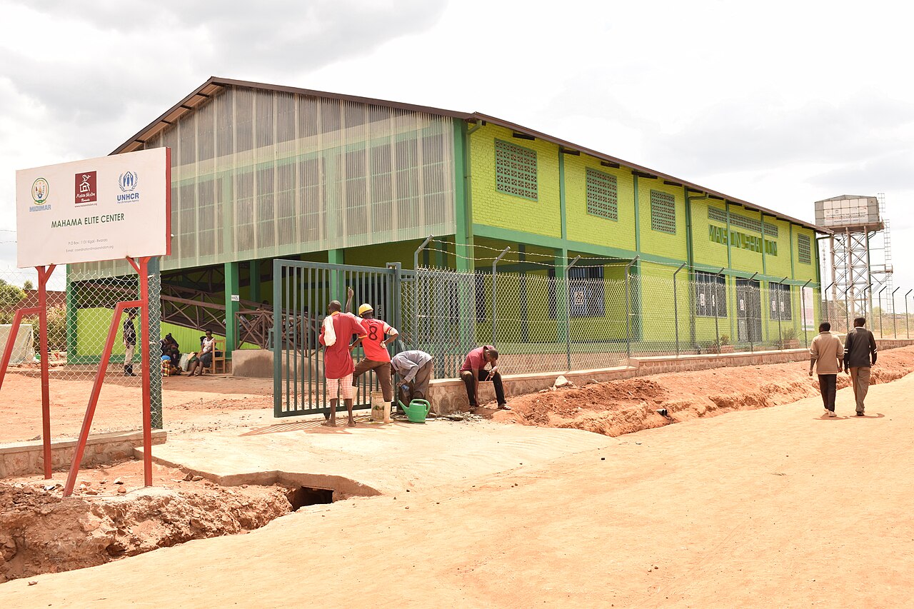 Workers and visitors outside the green two-storey Mahama Elite Center at Mahama refugee camp in eastern Rwanda