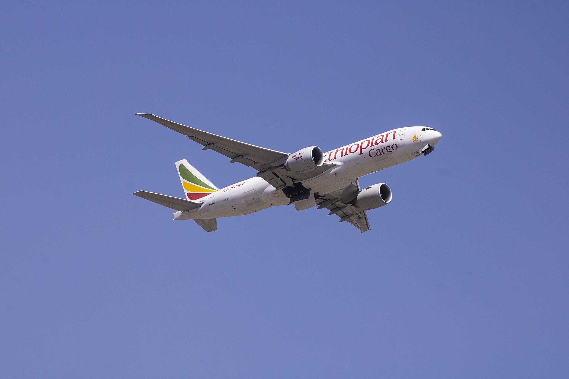 An Ethiopian Airlines Cargo Boeing 777 freighter in flight against a blue sky