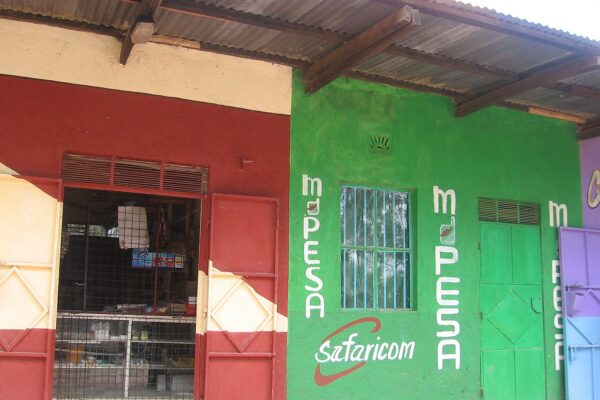 Green-painted Kenyan roadside shop with M-Pesa and Safaricom signs on its wall