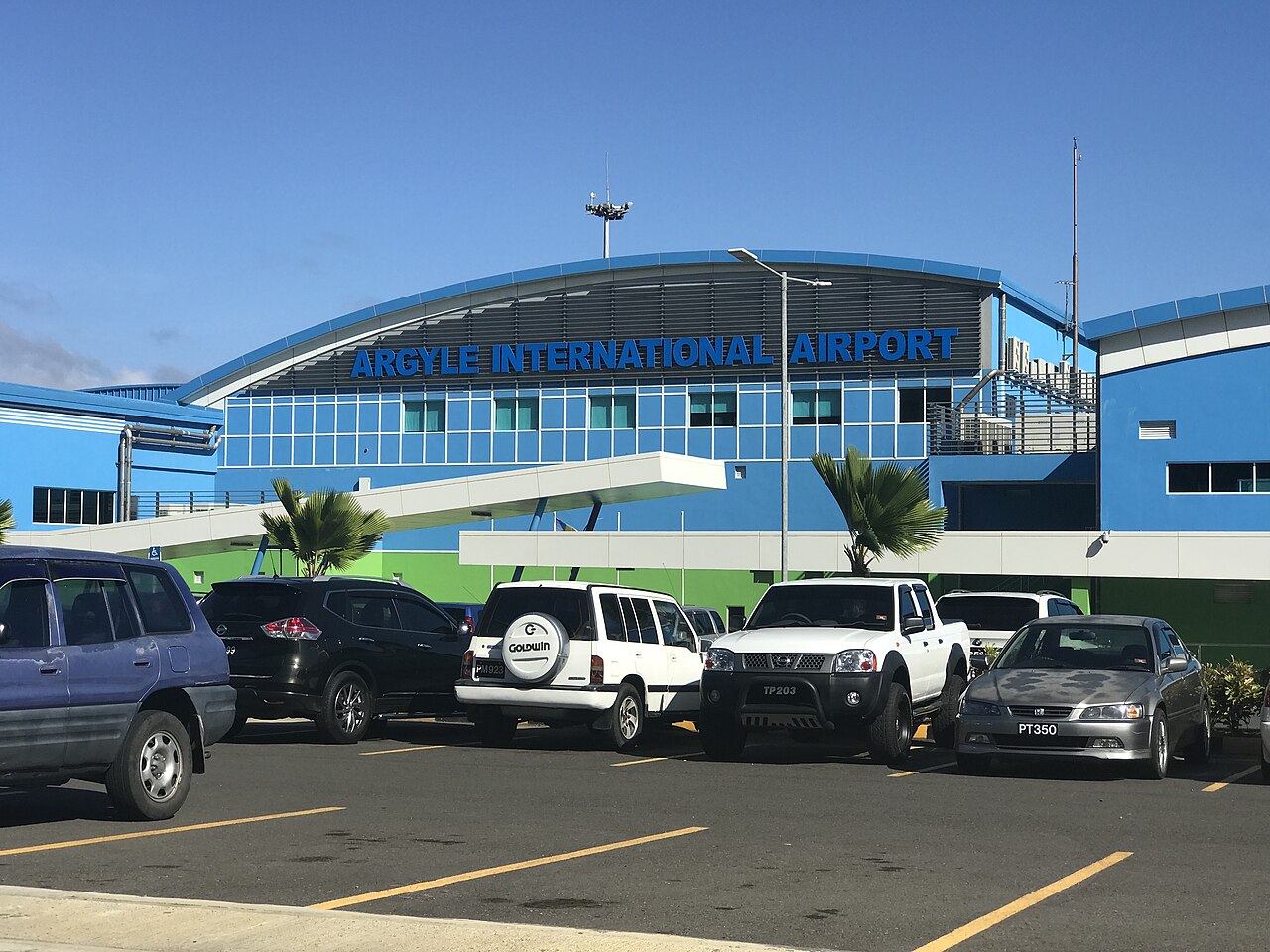 Blue terminal building of Argyle International Airport with cars parked in front, Saint Vincent