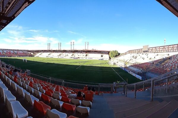 Interior of the Estadio Zorros del Desierto in Calama, Chile, a football stadium with orange and white seats facing the pitch