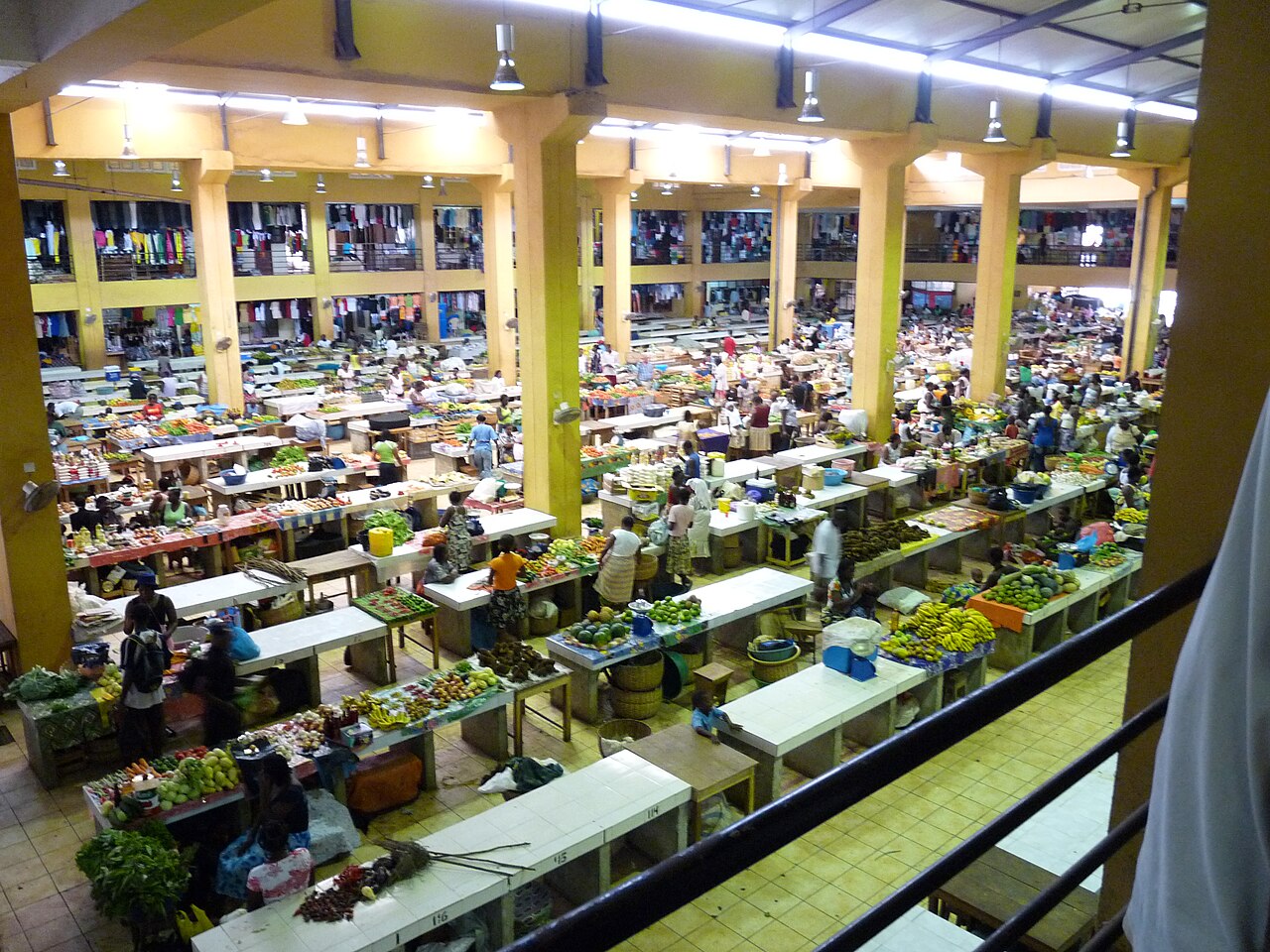 Stalls of fruit and vegetables seen from above in the covered market hall of Sao Tome