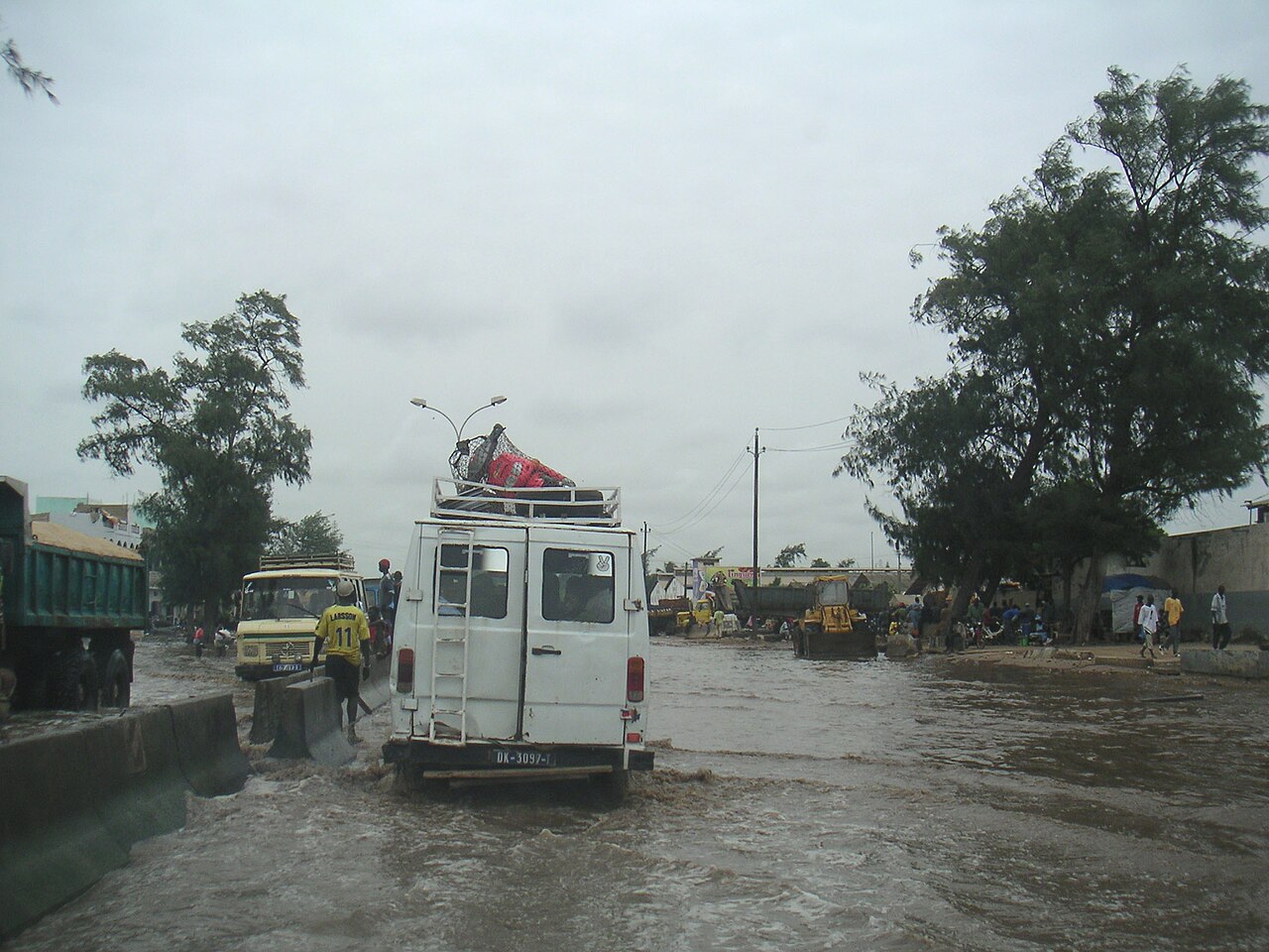 Minibuses and trucks driving through a flooded road in Dakar, Senegal, during the rainy season