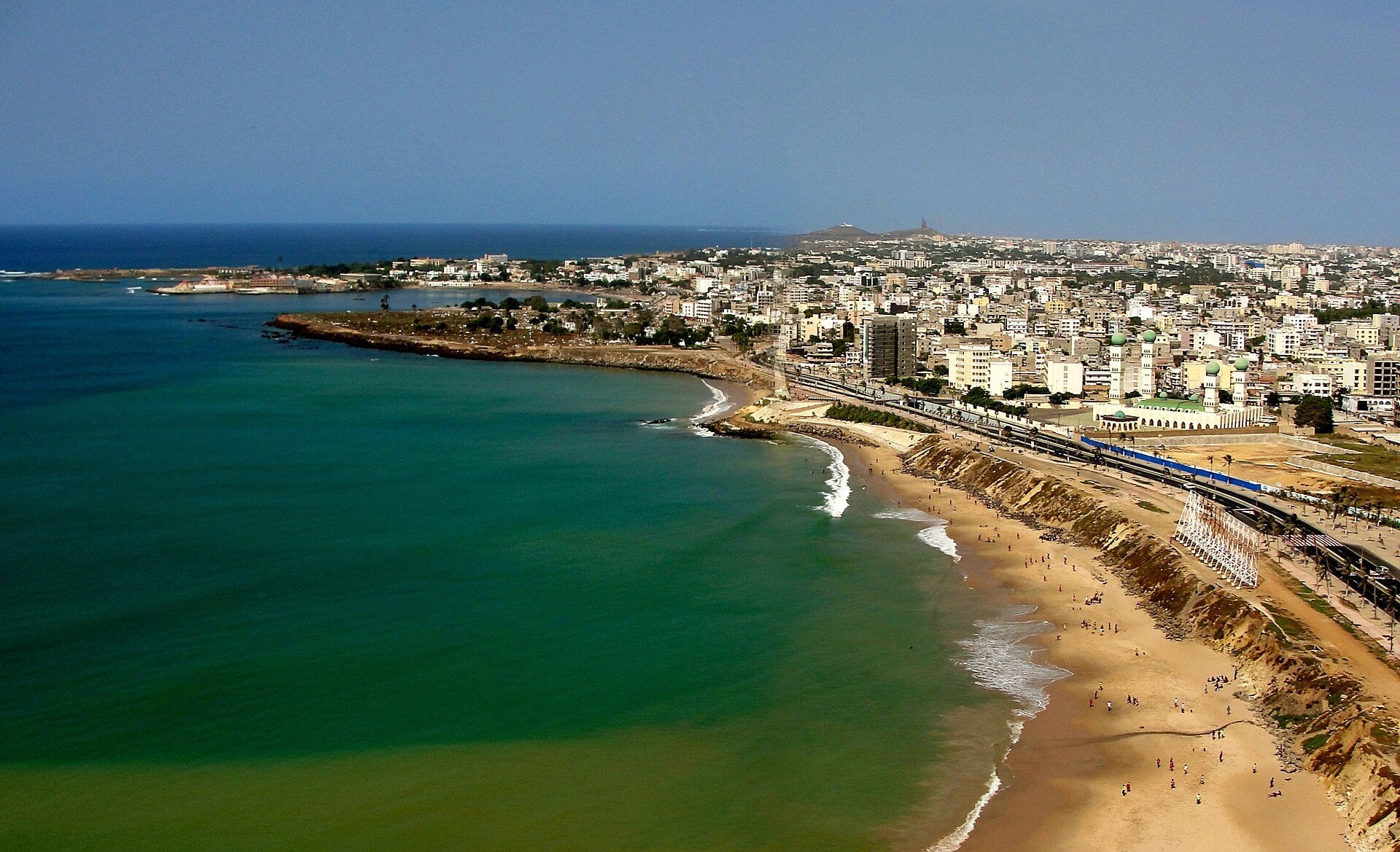 Aerial view of Dakar's Atlantic coastline, beach and city neighbourhoods under a clear sky
