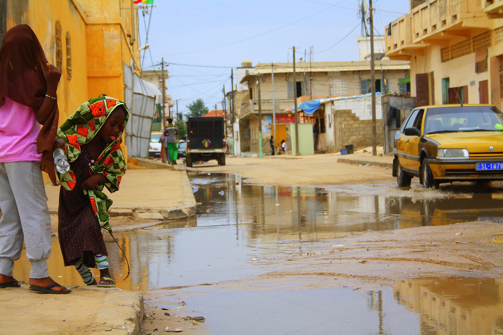 A child steps around a flooded street in Saint-Louis, Senegal, after rain