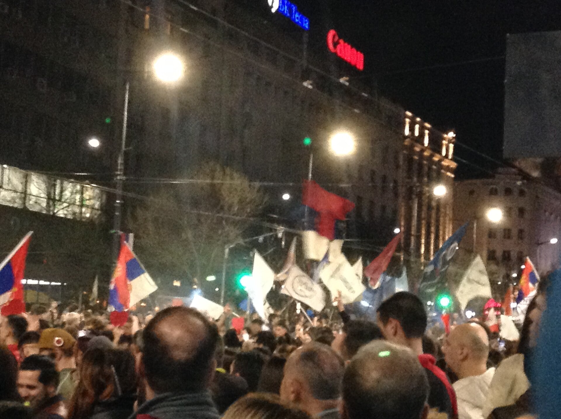 Crowd waving Serbian flags at a night protest in central Belgrade