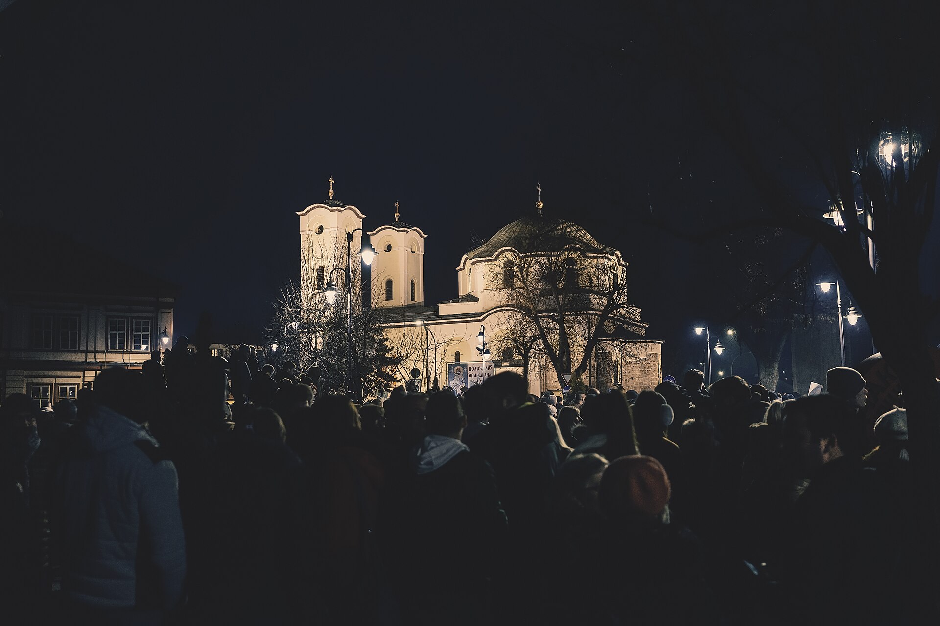 Protesters at night in front of a church in Čačak, Serbia, in January 2025