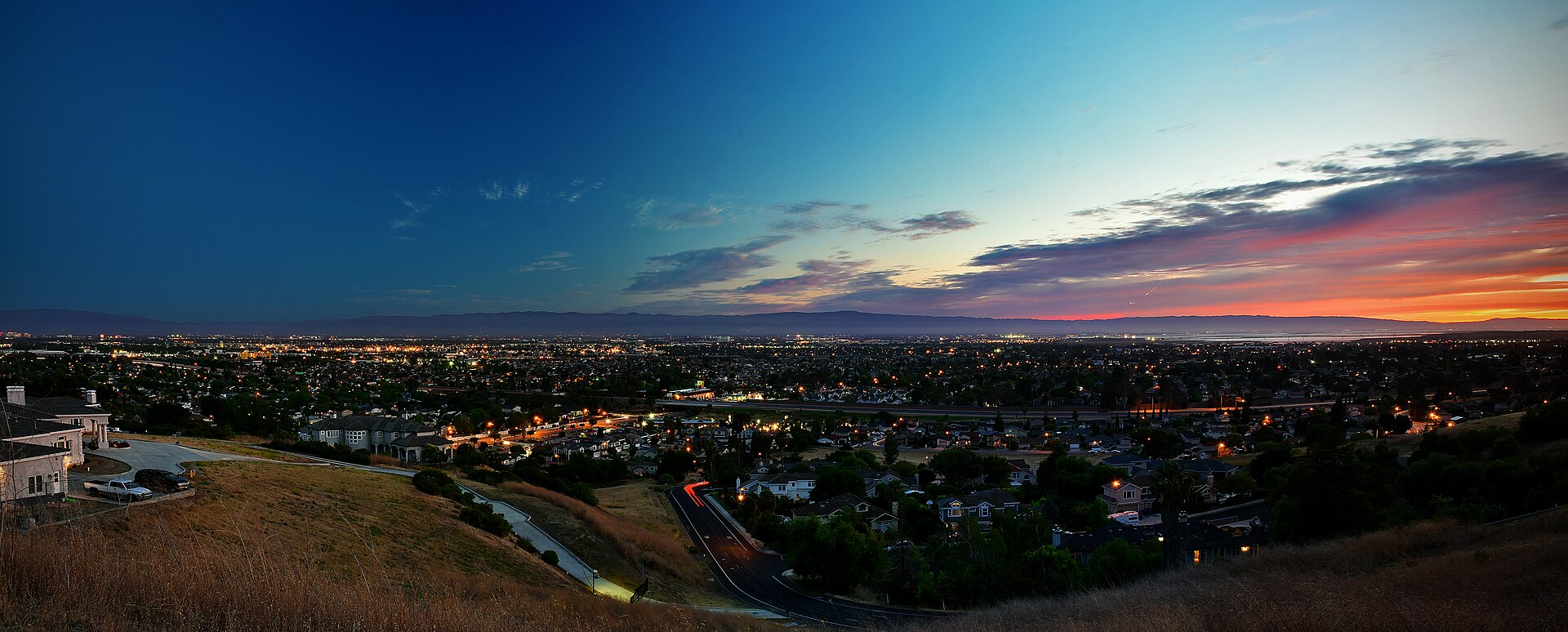 View over Silicon Valley at dusk with city lights and mountains on the horizon