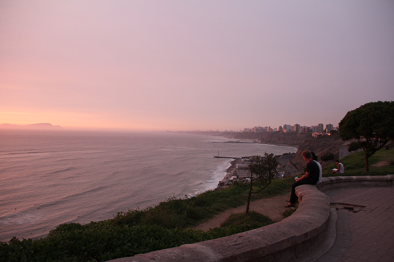 The sea, cliffs and apartment towers of Lima's Costa Verde coastline seen from the Barranco clifftop at sunset.