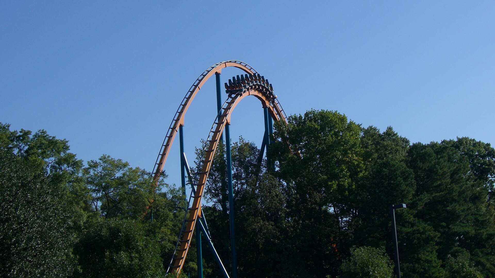 The first hill of the Goliath roller coaster at Six Flags Over Georgia with a train at the top, seen over trees in a file photo