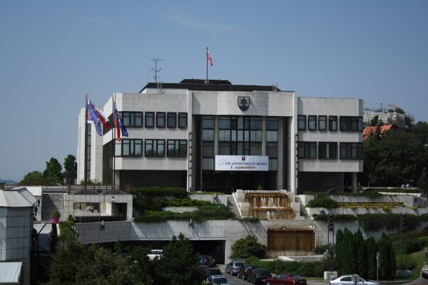 The modern white-stone National Council building in Bratislava with the Slovak and EU flags