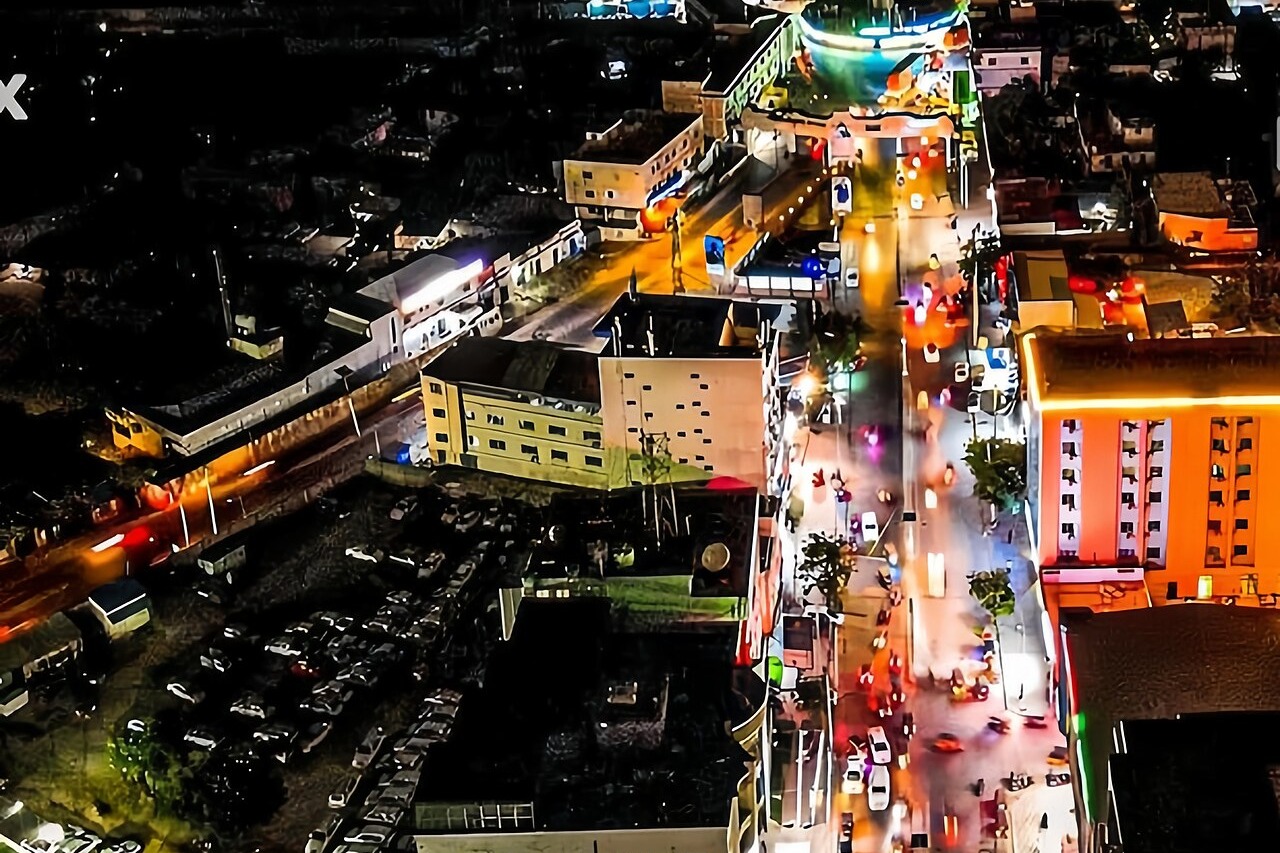 Aerial view of a busy Mogadishu avenue lit up at night, with traffic and buildings