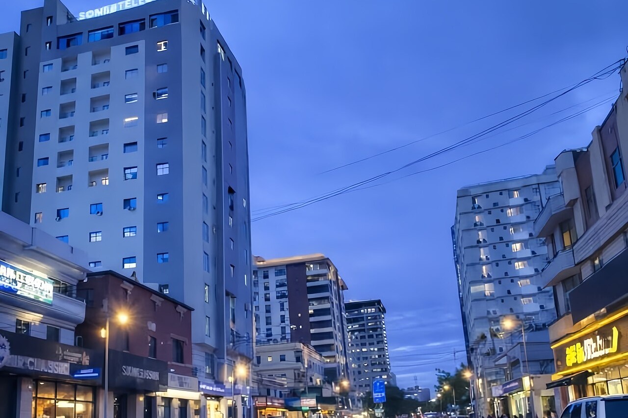 Apartment towers and shops lining a Mogadishu street at dusk
