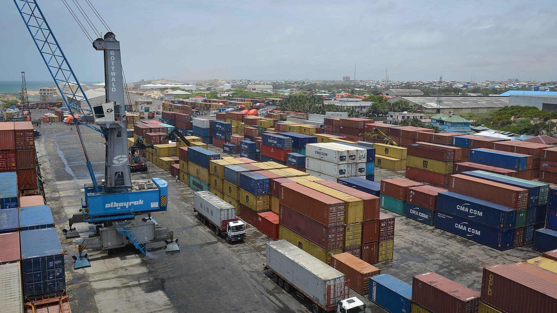 Shipping containers stacked in rows beside a port crane at Mogadishu port in Somalia