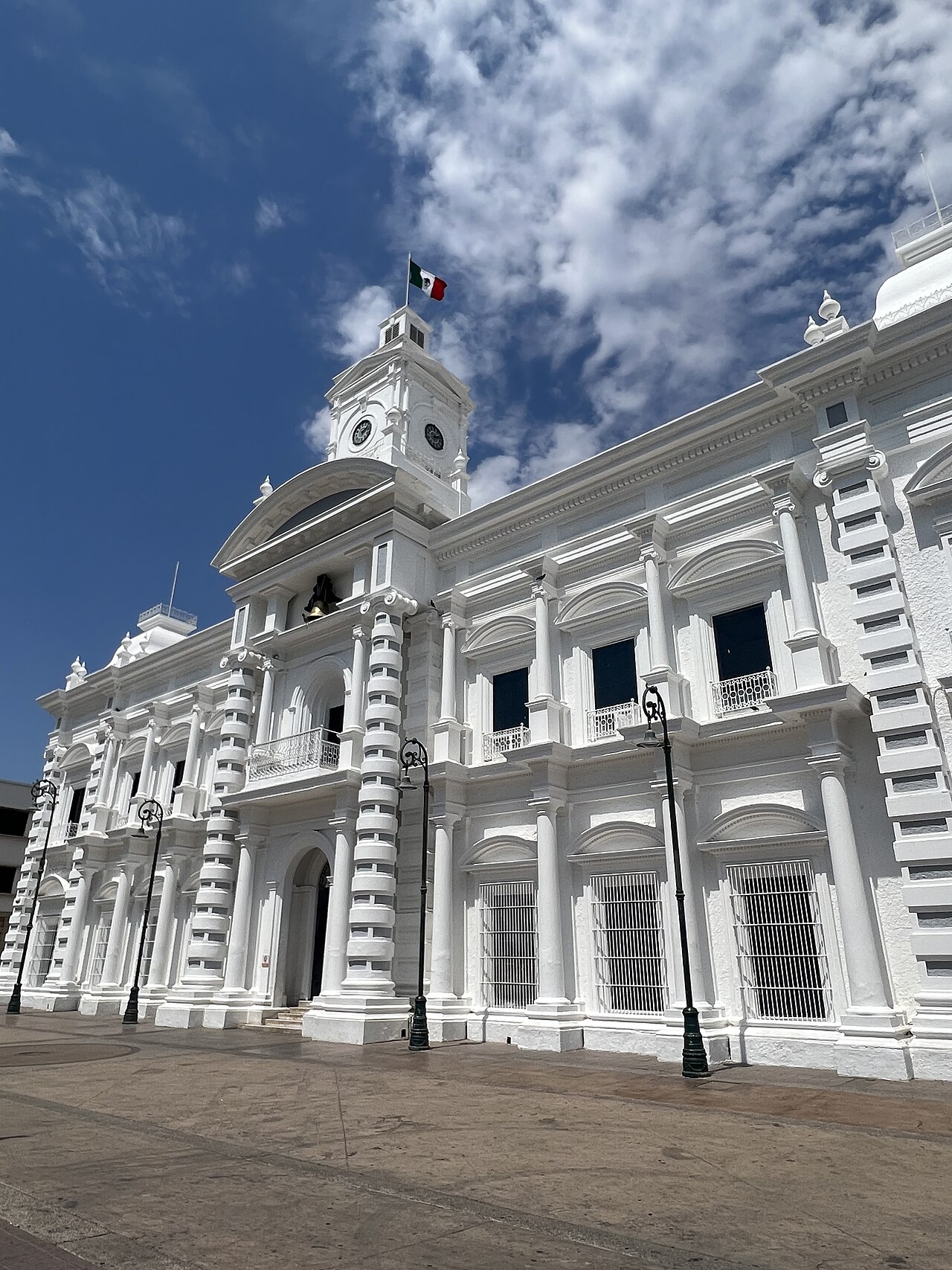White facade and clock tower of the Sonora state government palace in Hermosillo flying the Mexican flag