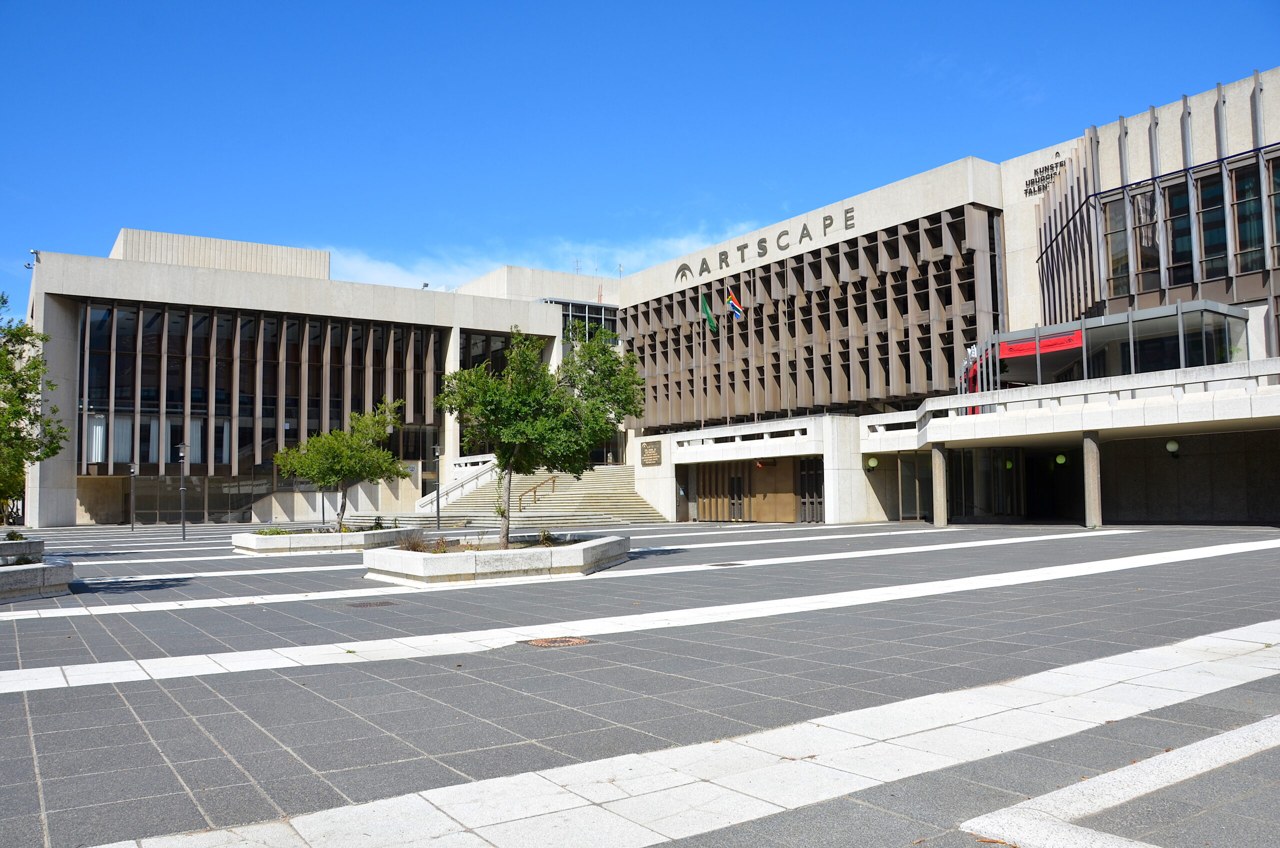 The Artscape theatre complex on a paved square in Cape Town, with South African flags above its entrance