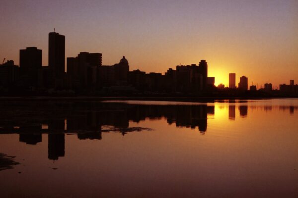 Durban skyline reflected in water at sunrise