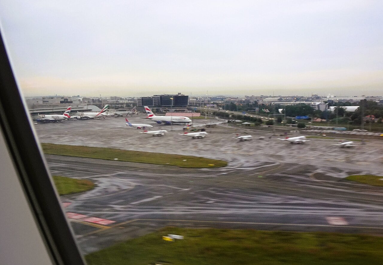 Passenger jets parked at the terminals of O. R. Tambo International Airport in Johannesburg on a wet, overcast day
