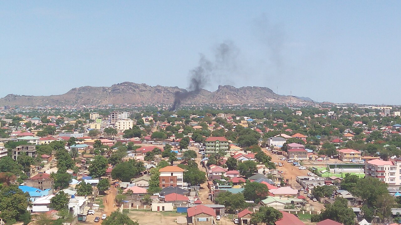 Rooftops and tree-lined streets of Juba, South Sudan's capital, with a rocky ridge on the horizon