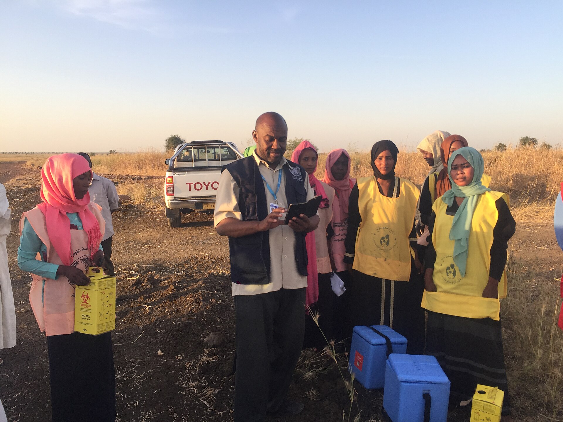 Health workers and a vaccination team in open savannah in Sudan's Blue Nile state