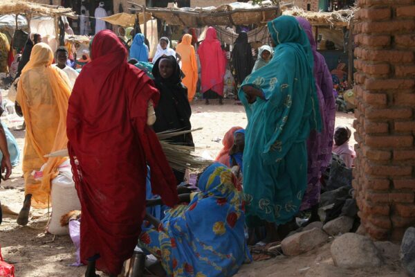 Women in bright headscarves and robes gather among stalls at a market in Darfur, western Sudan, in a 2008 photo