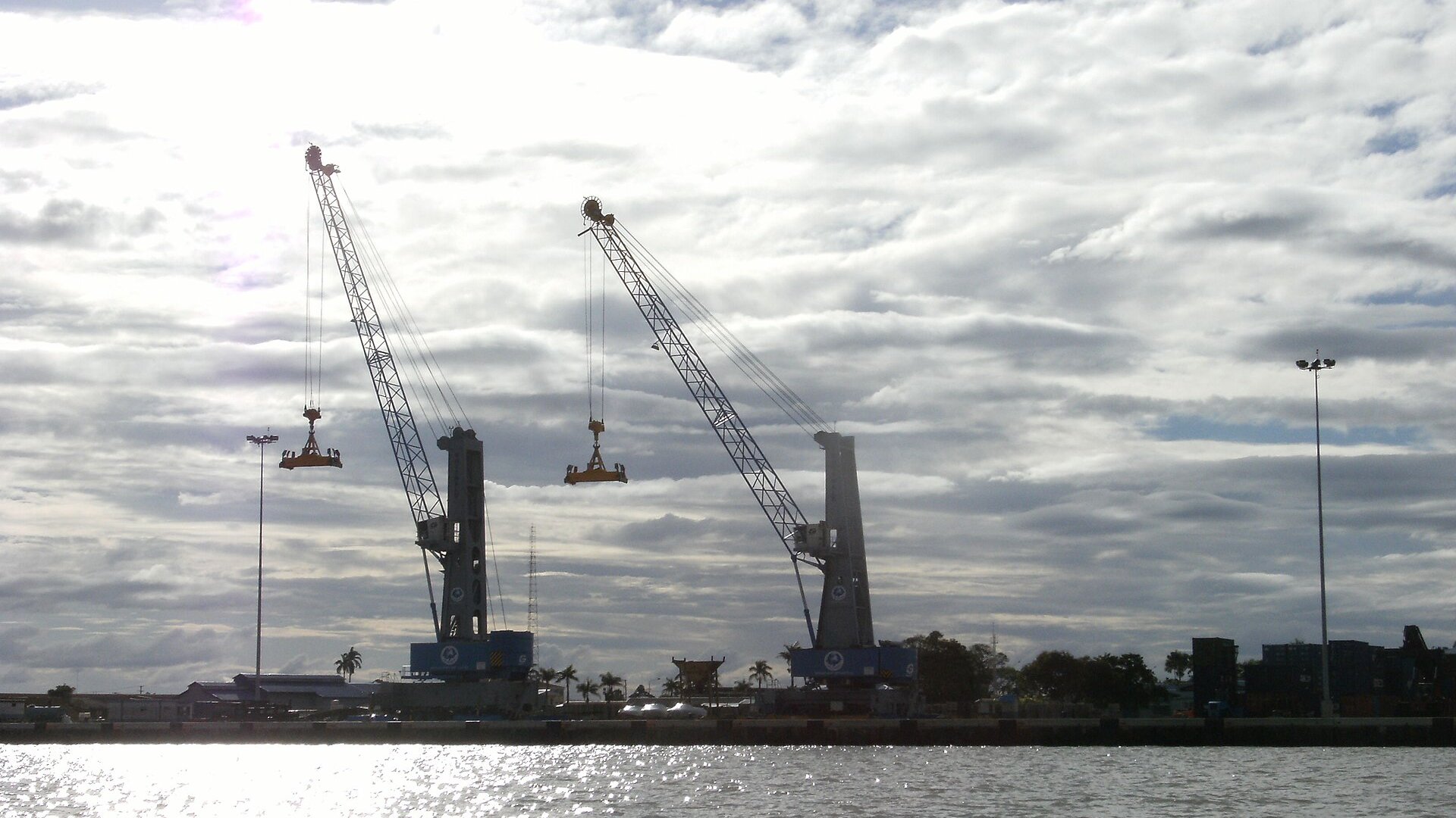 Two port cranes lifting container spreaders at the harbor of Paramaribo, Suriname