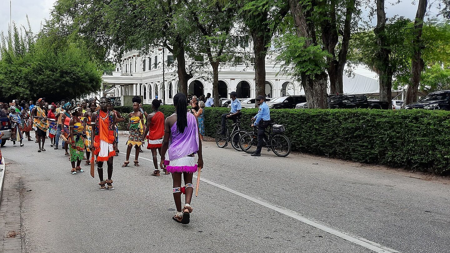 Dancers in colourful costume walk along a street in Paramaribo during a parade