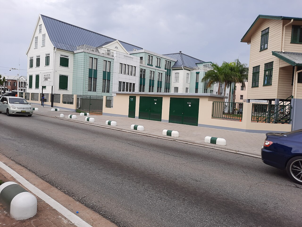 Colonial-style wooden buildings and a modern annex along a street in Paramaribo, Suriname's capital