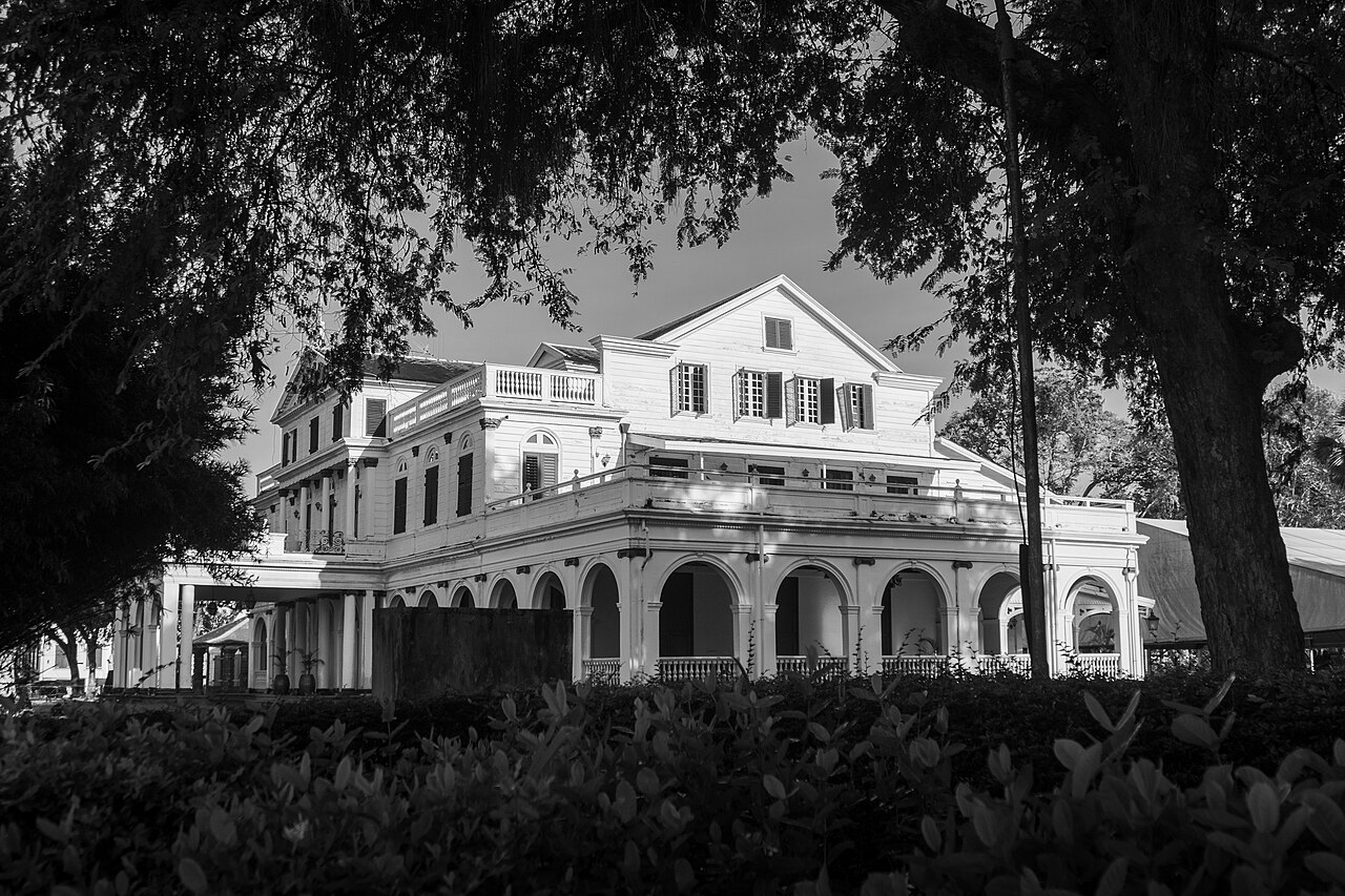 Black-and-white view of the white colonial Presidential Palace in Paramaribo through trees