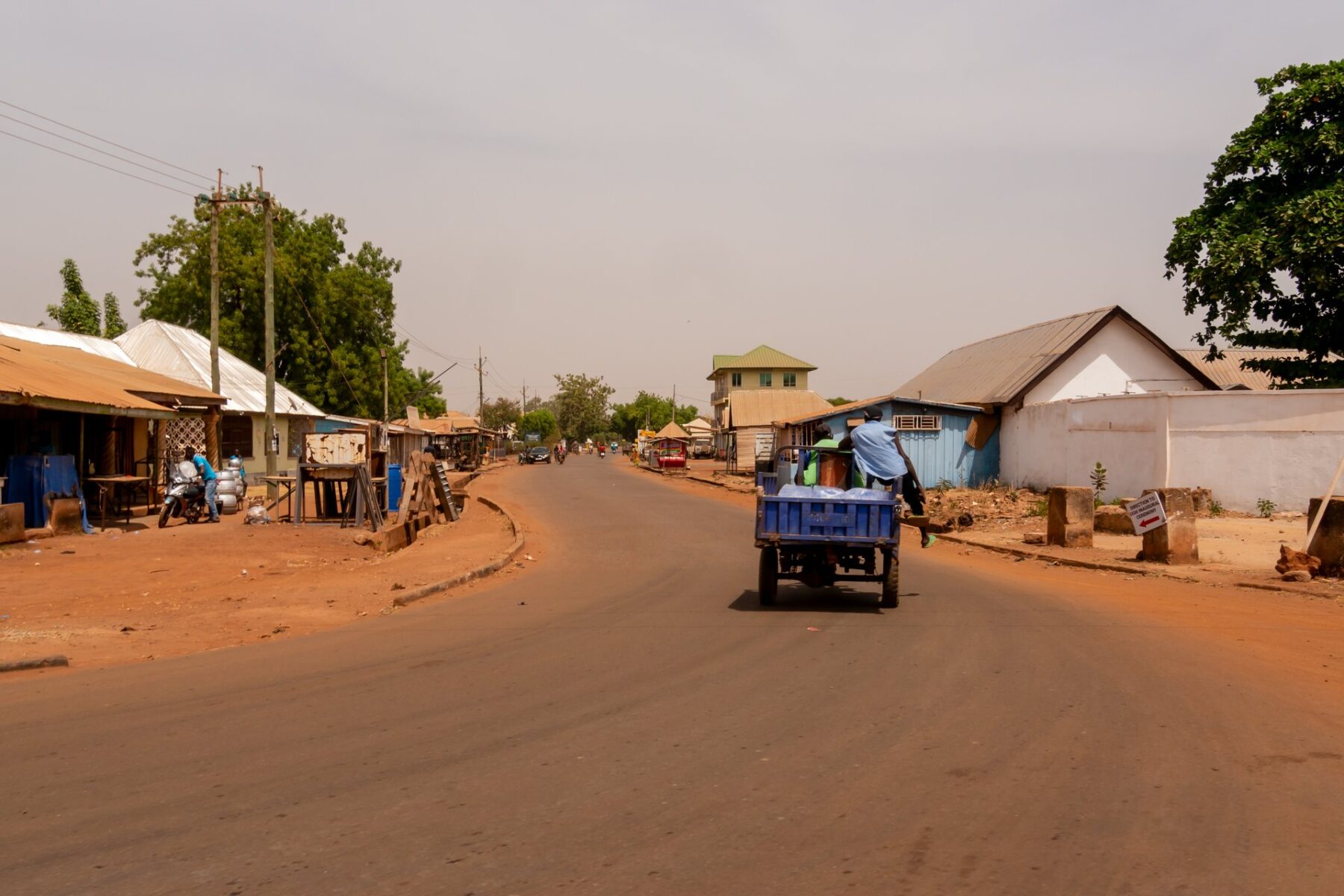 A street with shops, trees and a small truck in Tamale, northern Ghana