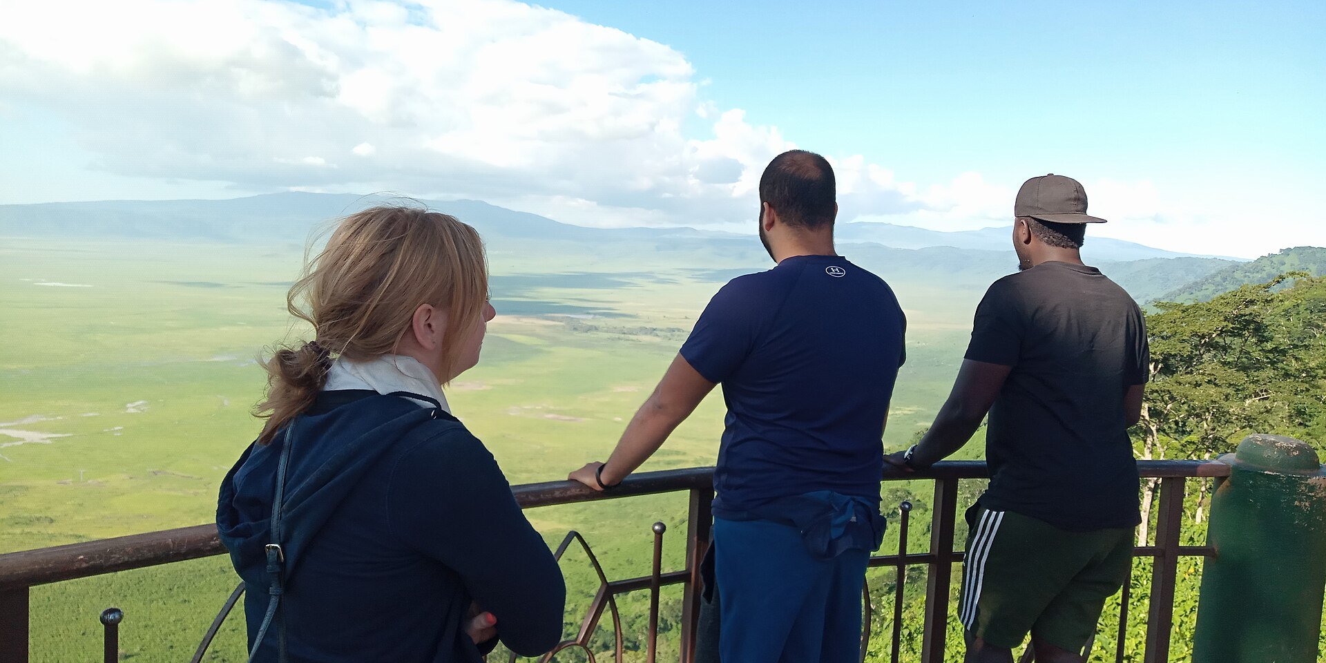 Visitors at a railing looking over the grassland floor of Ngorongoro Crater in northern Tanzania