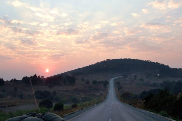 A paved road climbing a hill at sunrise outside Mbeya, Tanzania